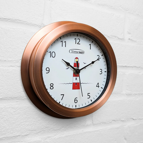 Wall clock with copper frame and lighthouse design on a white background

