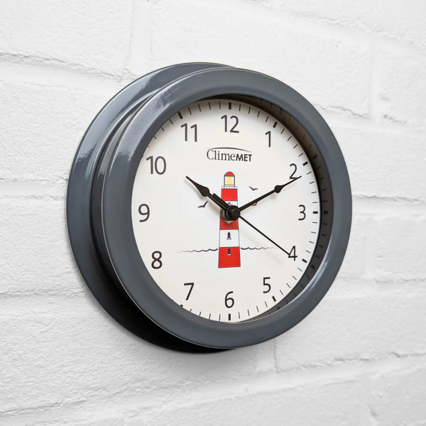 Wall clock with grey frame and lighthouse design on a white background

